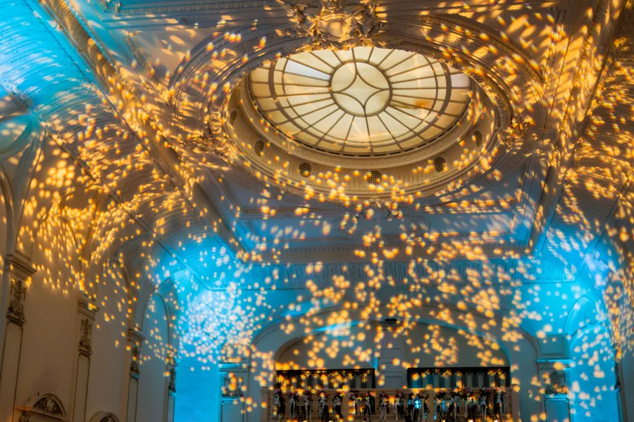 Bride and groom dancing beneath warm reception lights — David and Katia wedding