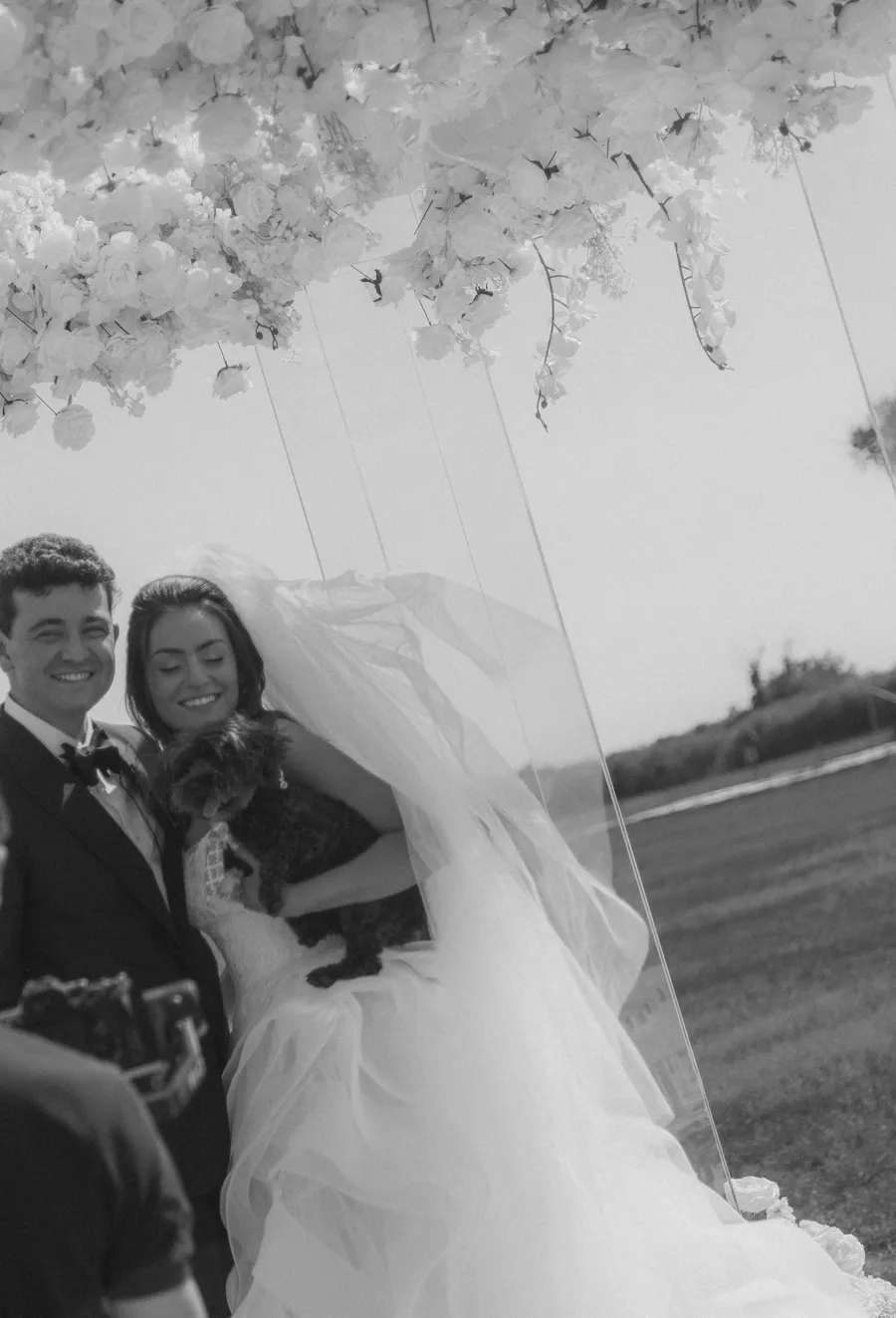 Newlyweds embracing at the flower-lined ceremony aisle — David and Katia wedding