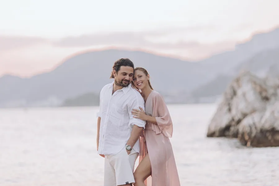 Parents embracing their young child beside the sea