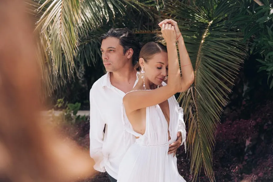 Couple dancing beneath palm trees during a destination celebration