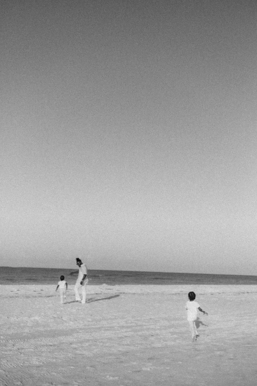 Black-and-white photograph of children playing at the water’s edge