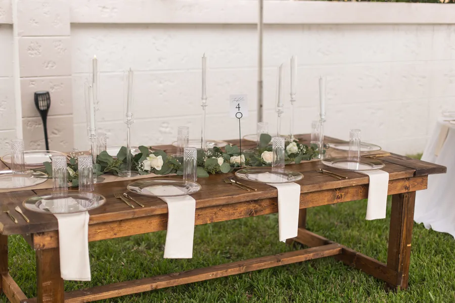 Long reception table styled with candles and greenery — Chris and Laura wedding