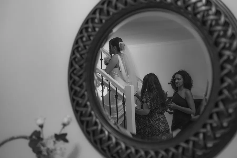 Black-and-white reflection of a bride getting ready with her family