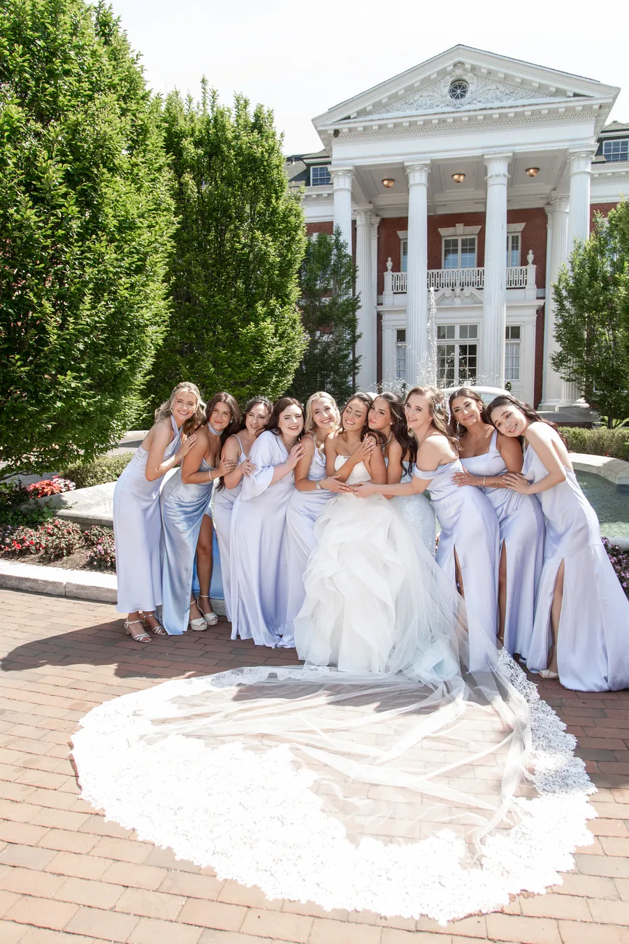 Bride and bridesmaids celebrating outside a grand columned venue