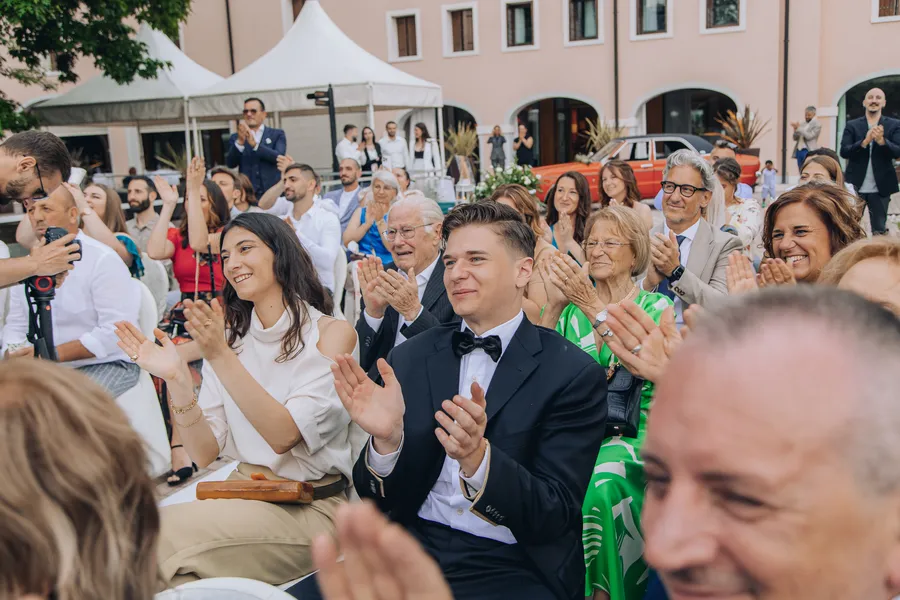 Wedding guests applauding during an outdoor celebration