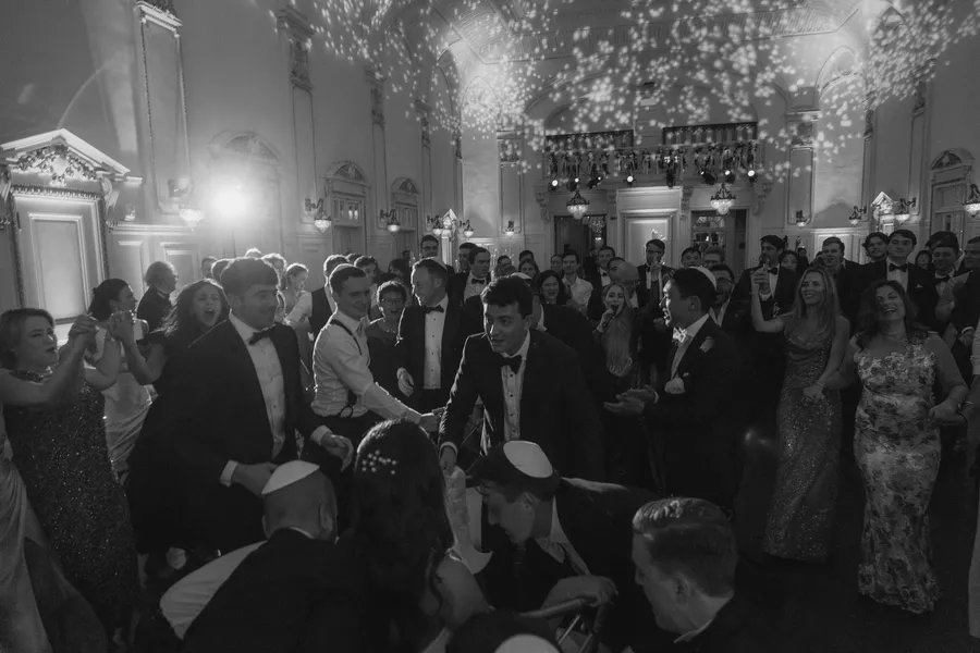 Black-and-white photograph of guests dancing at the reception