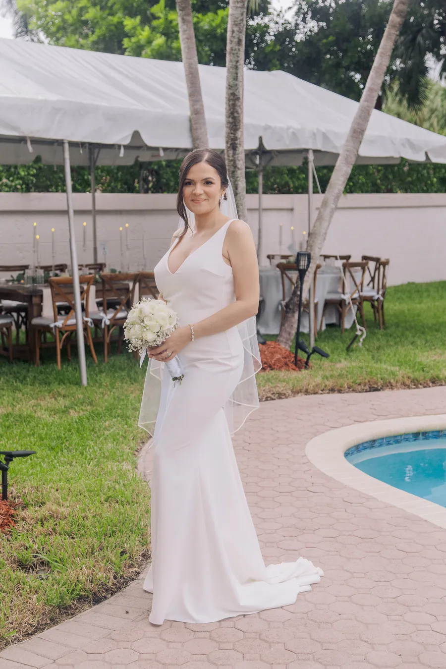 Newlyweds sharing their first kiss beside the pool — Chris and Laura wedding