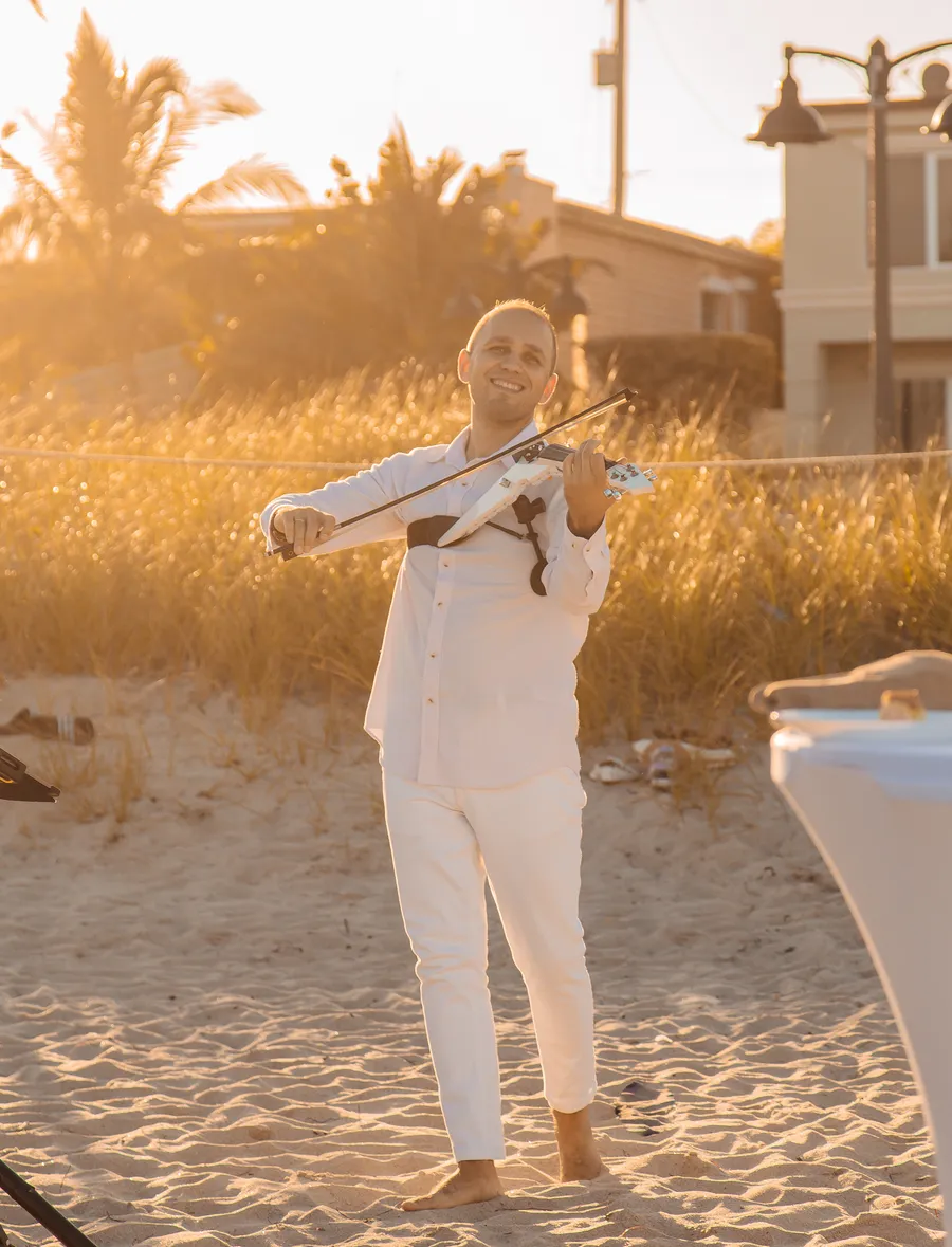 Sunset portrait of a wedding guest on the sand — Roman and Victoria wedding