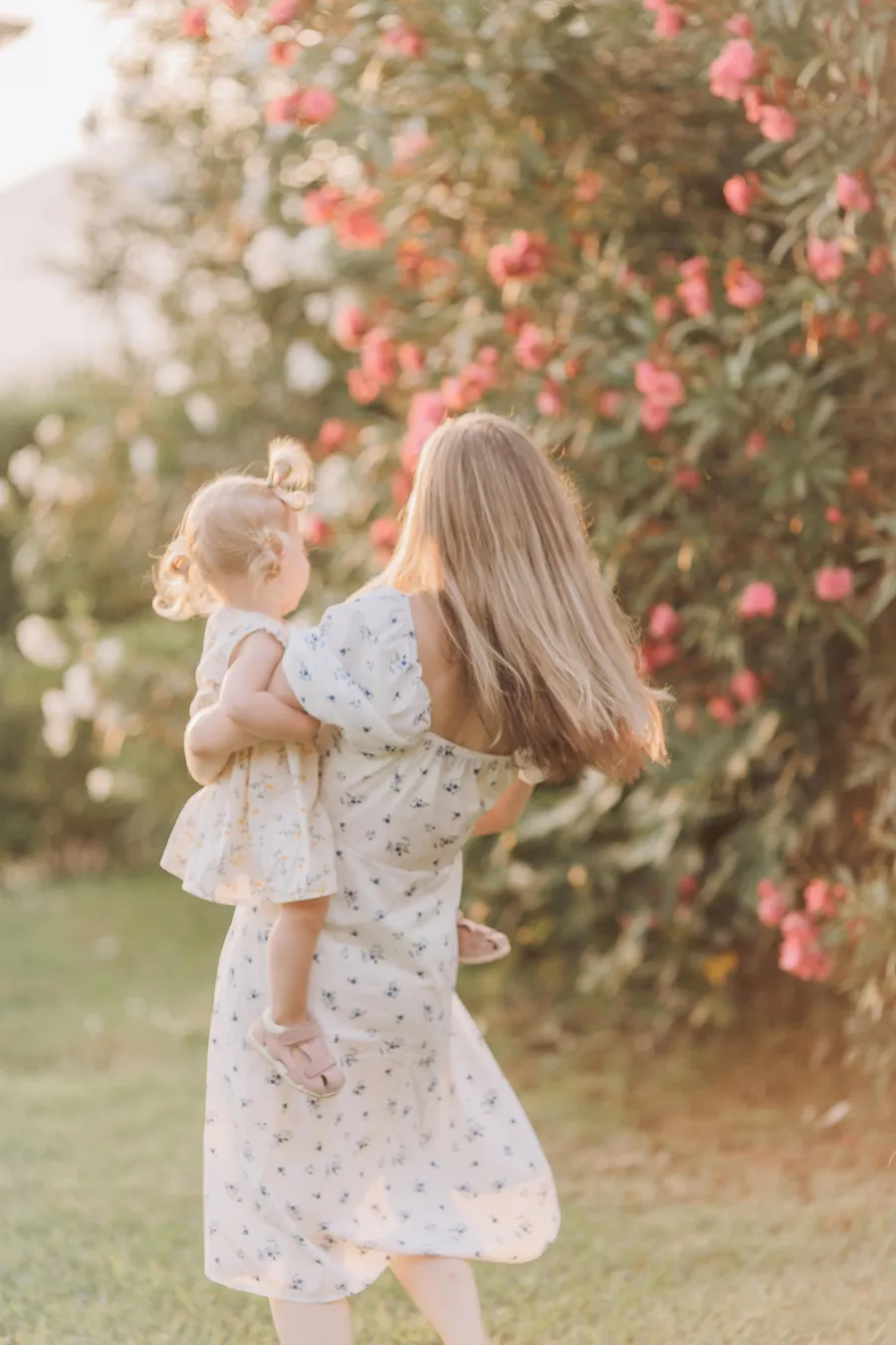 Mother and daughter walking together in a flower garden