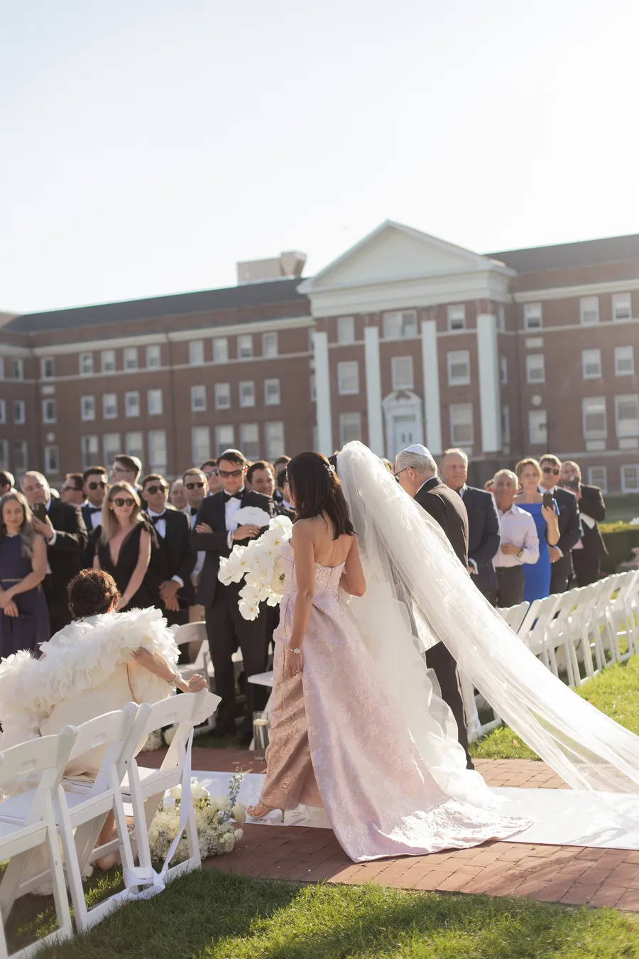 Bride and groom beneath a white floral arch — David and Katia wedding