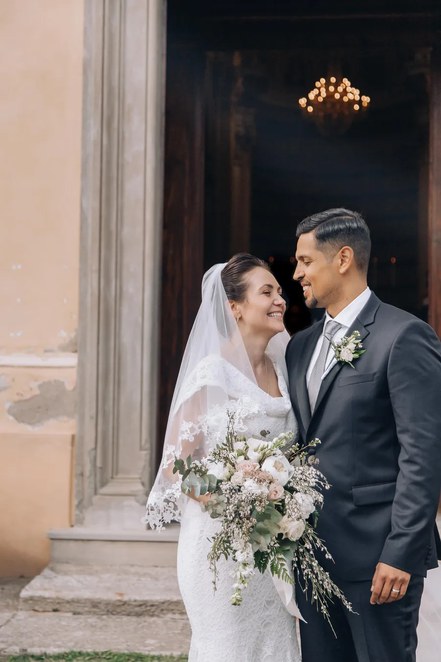 Newlyweds embracing outside a historic wedding venue