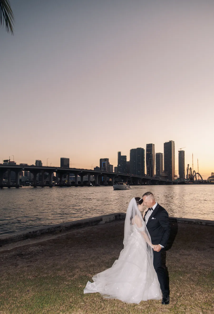 Bride and groom embracing beside the evening skyline — Steven and Iryna wedding