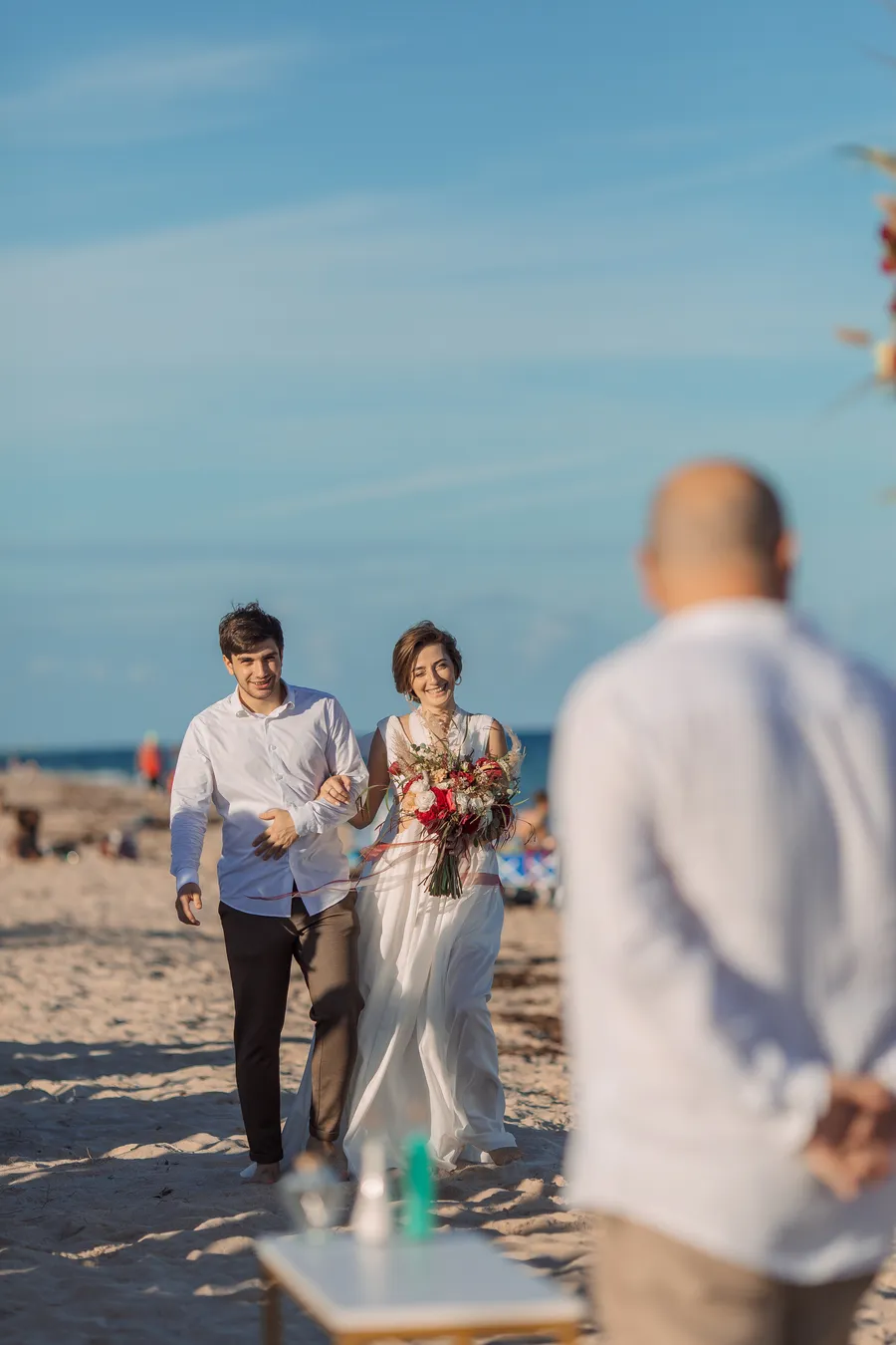 Reception table and ceremony chairs arranged on the sand — Roman and Victoria wedding