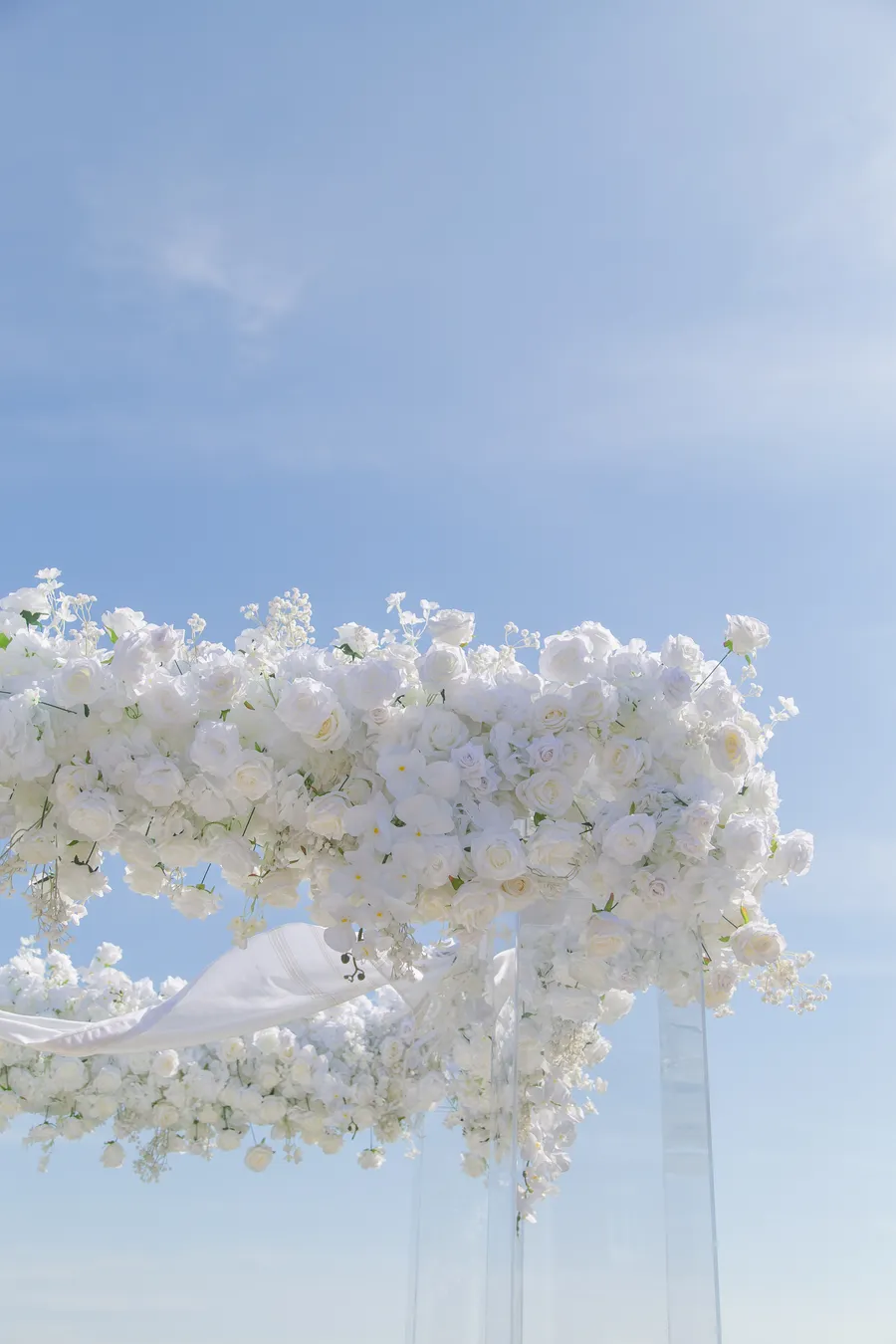 Newlyweds embracing at the flower-lined ceremony aisle — David and Katia wedding