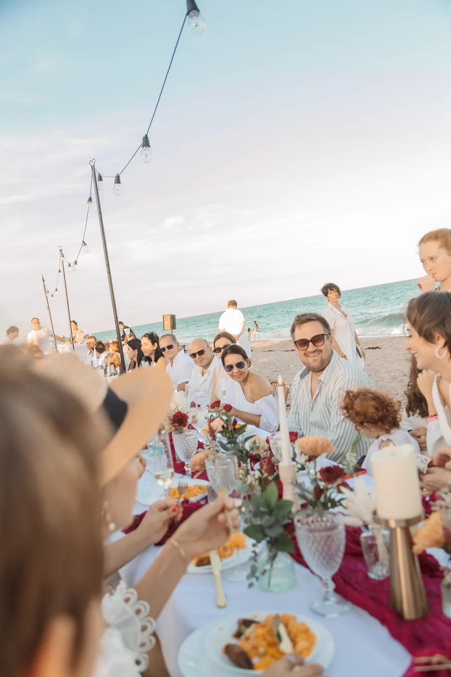 Bride holding a child during the beach reception — Roman and Victoria wedding