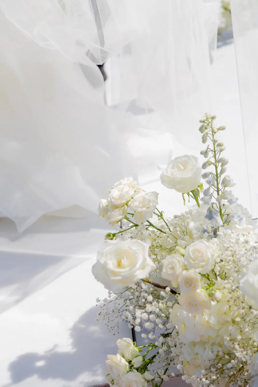 Groom waiting beneath the wedding ceremony flowers — David and Katia wedding