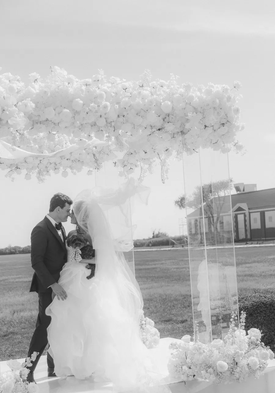 Outdoor ceremony prepared with a white floral arch — David and Katia wedding
