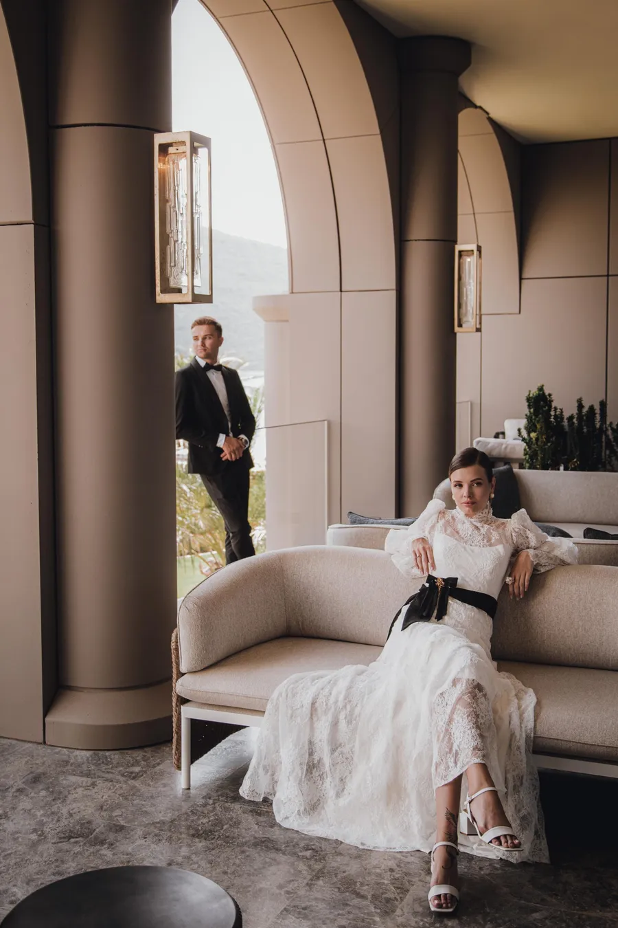 Bride seated in a quiet arched room before the ceremony