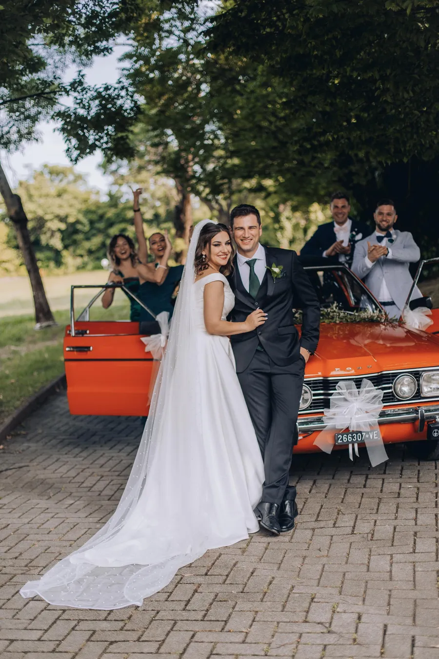 Newlyweds posing beside a red vintage car — Mattia and Yulia wedding