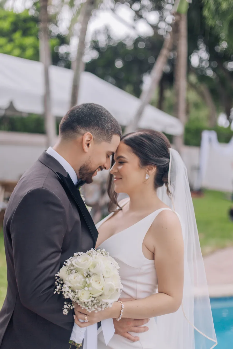 Newlyweds sharing their first kiss beside the pool — Chris and Laura wedding