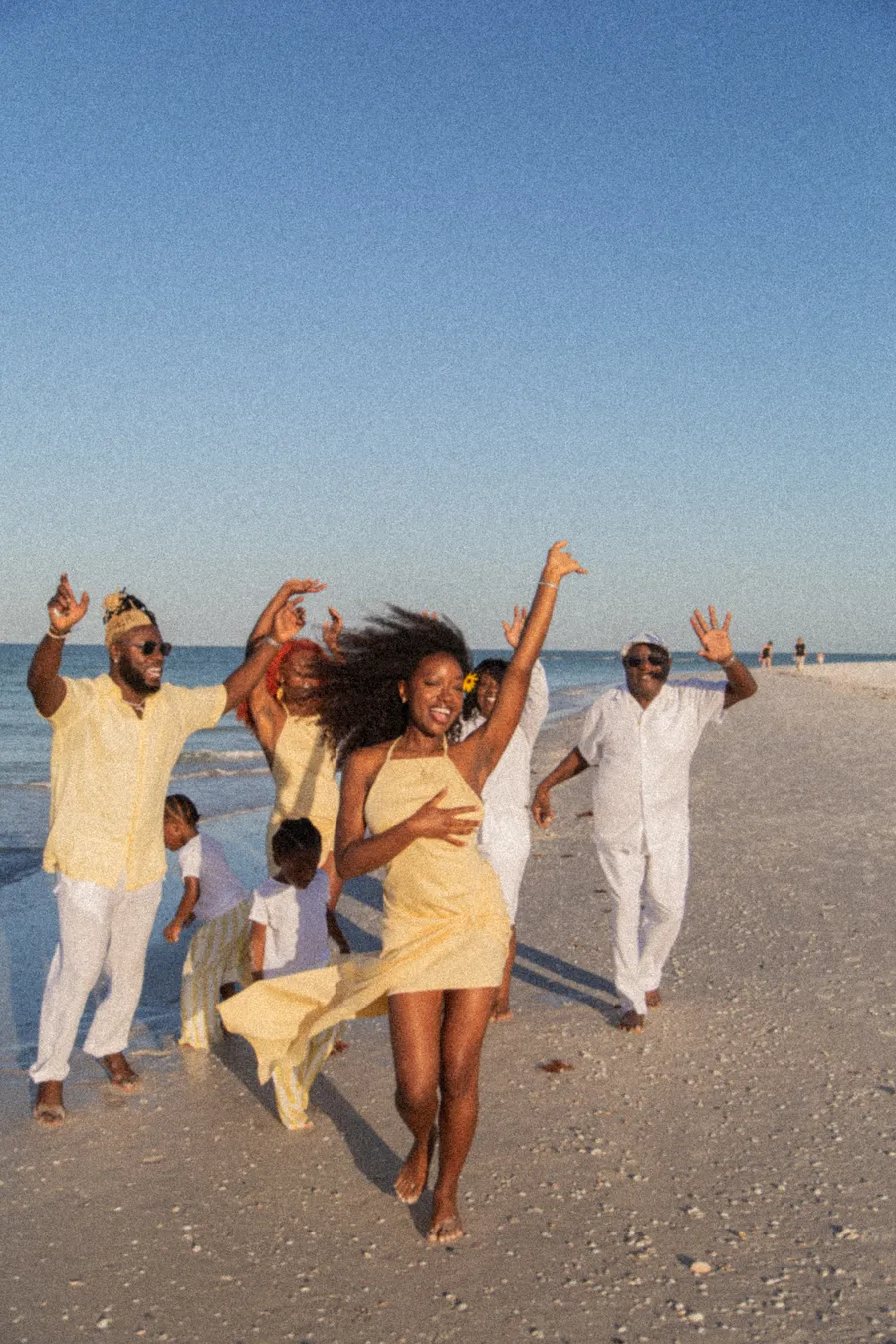 Family running toward the camera during a playful beach session