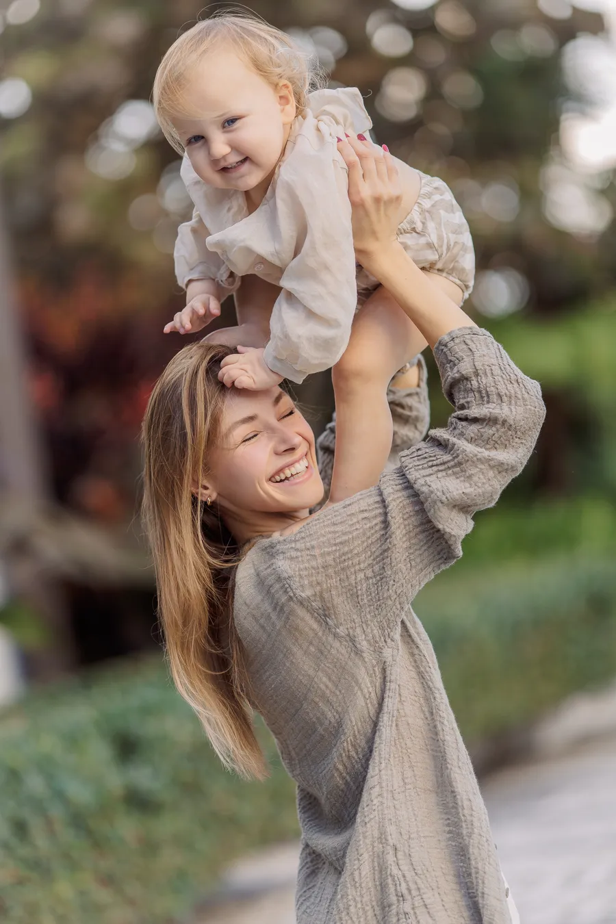Mother carrying her smiling child on her shoulders outdoors