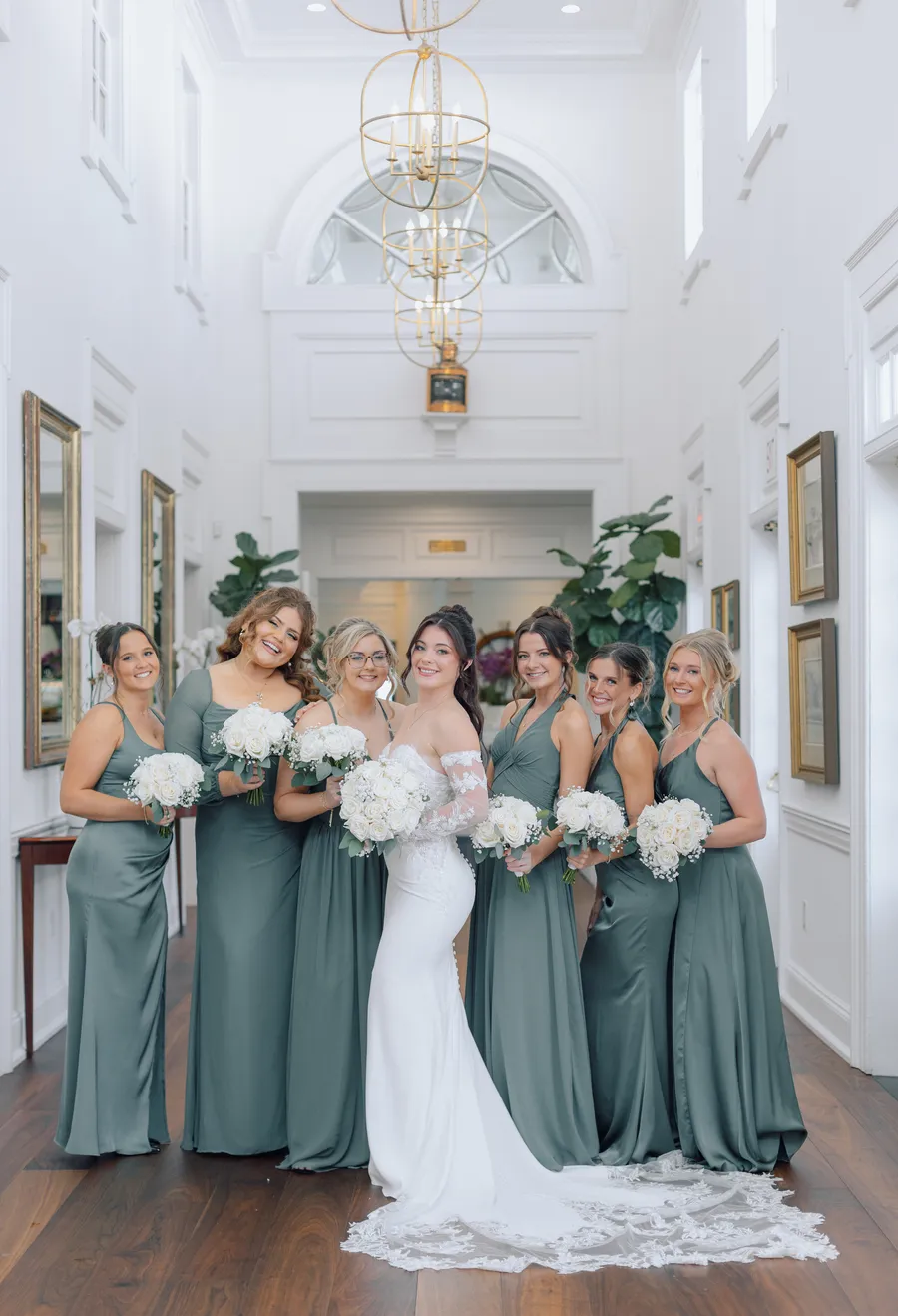 Bride and bridesmaids posing inside a bright reception hall