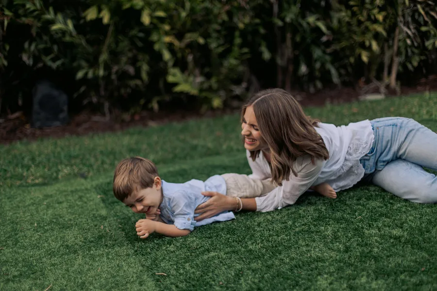 Mother and young child playing together on the lawn