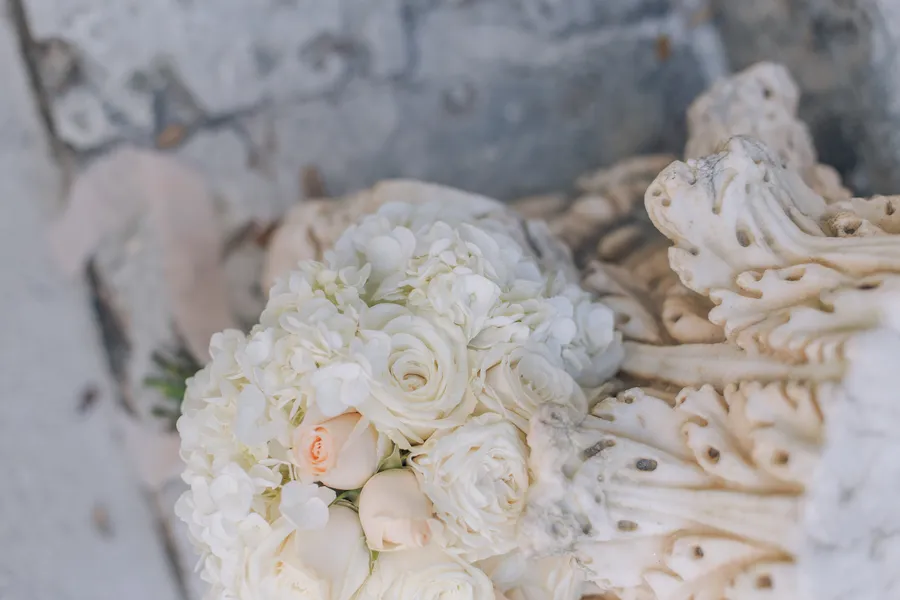 White bridal bouquet resting beside the wedding dress — Steven and Iryna wedding