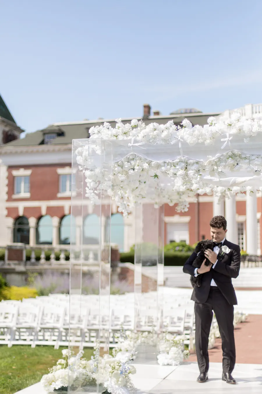 Groom waiting beneath the wedding ceremony flowers — David and Katia wedding