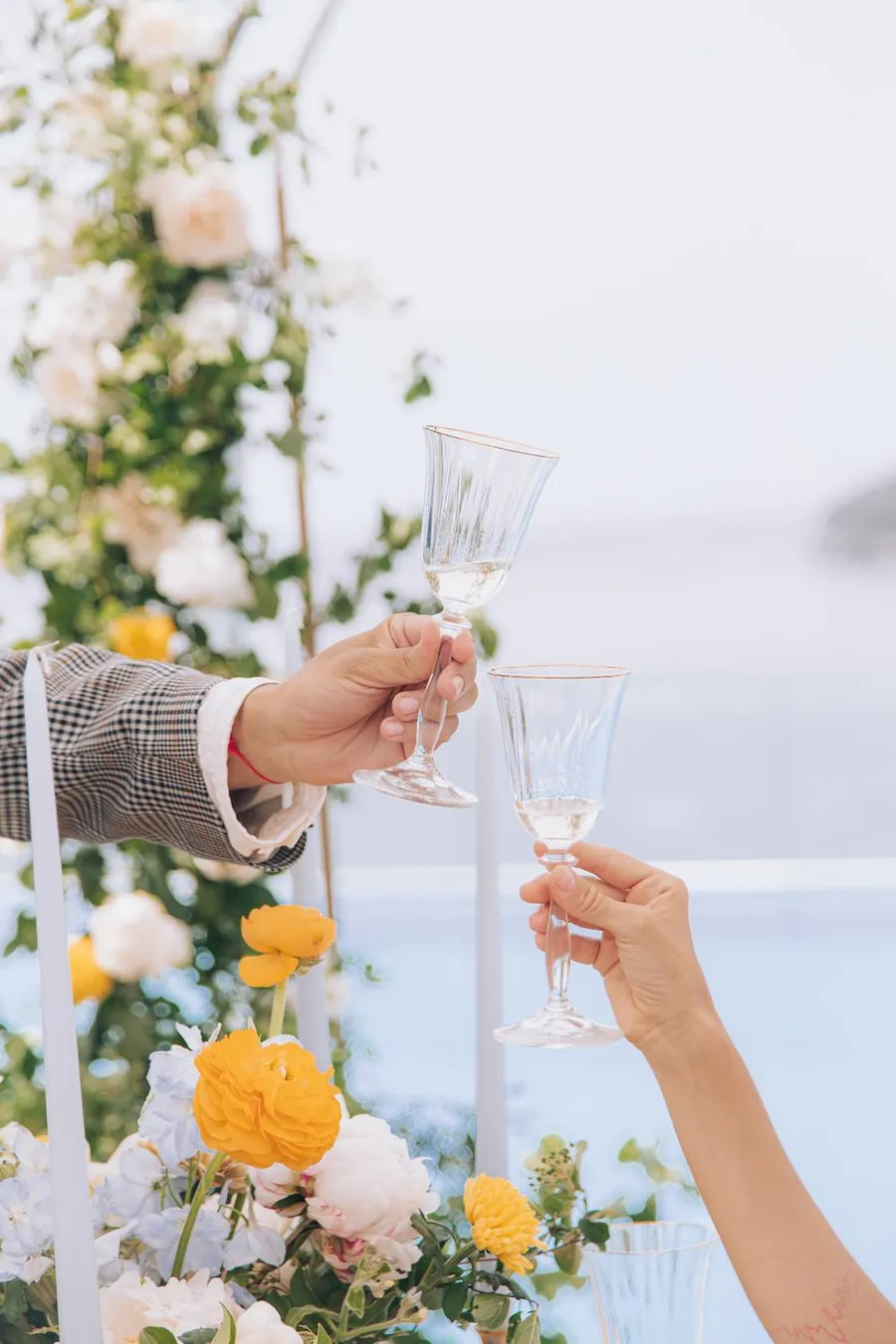 Wedding toast with champagne glasses and bright floral decor
