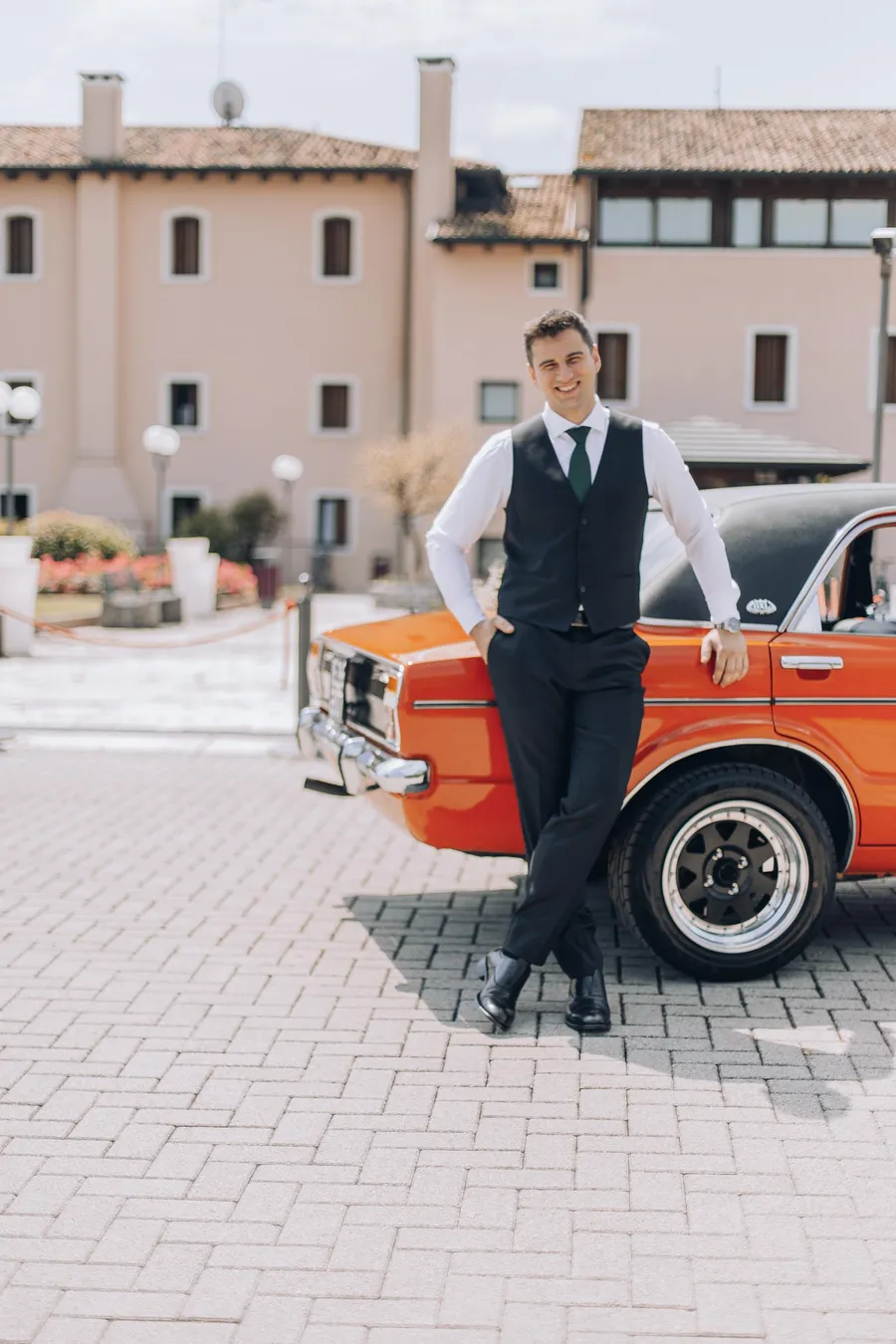 Newlyweds posing beside a red vintage car — Mattia and Yulia wedding