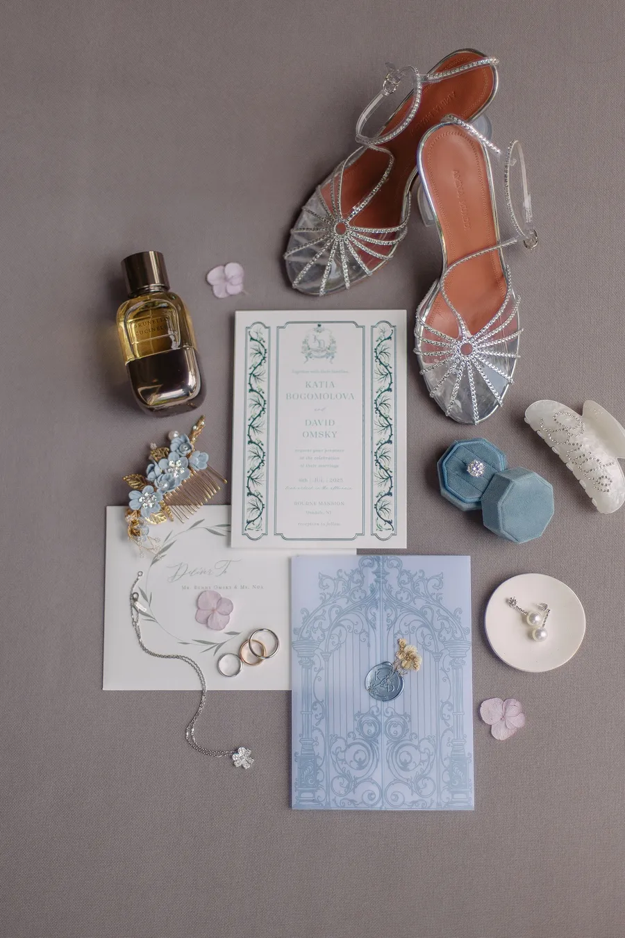 Wedding stationery, perfume and bridal accessories arranged together — David and Katia wedding