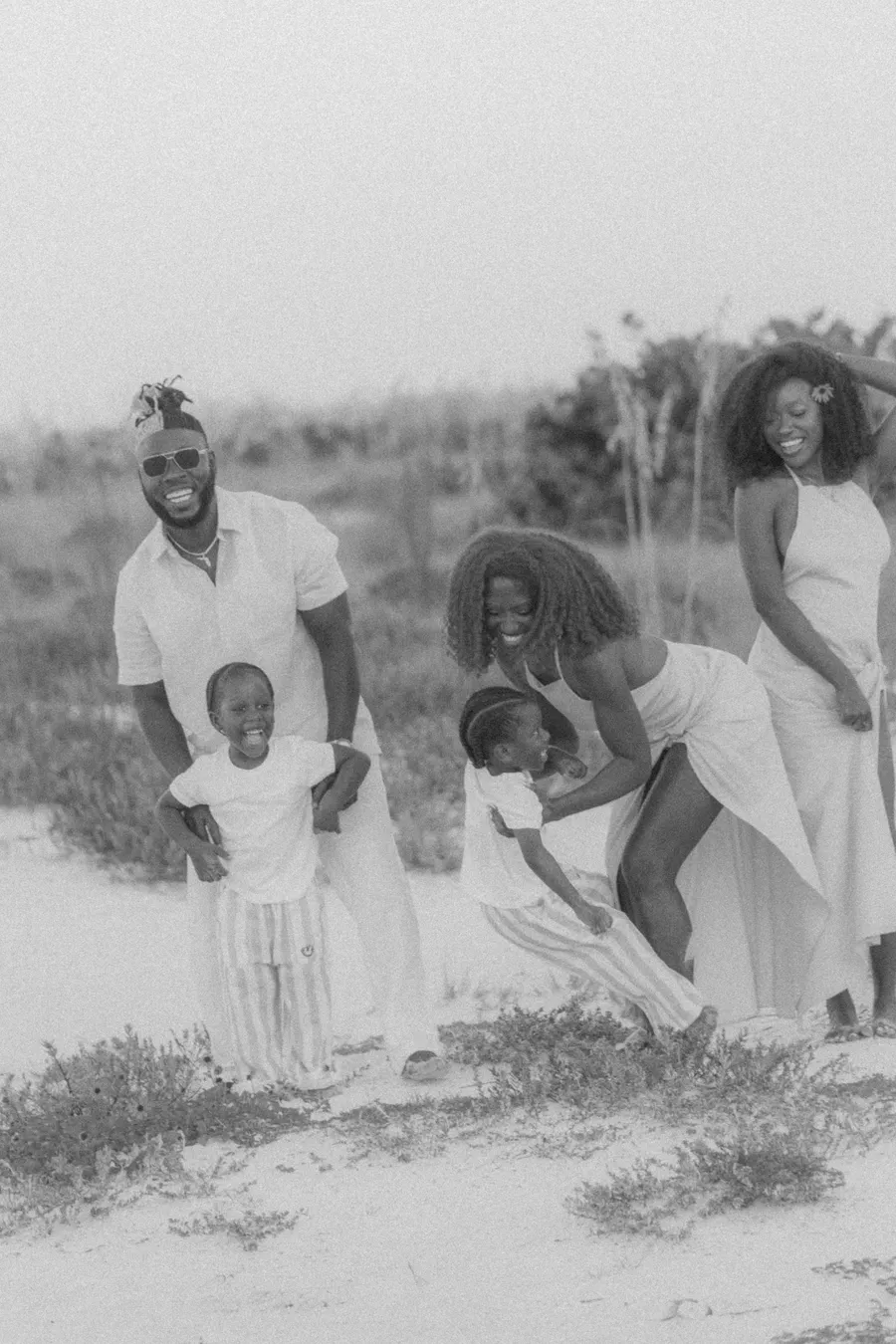 Black-and-white photograph of a family playing together at the beach
