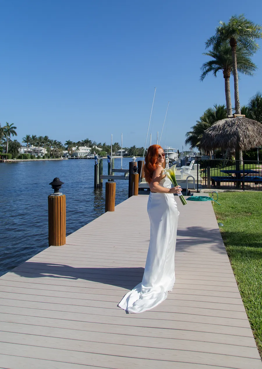 Bride walking along a waterfront ceremony aisle