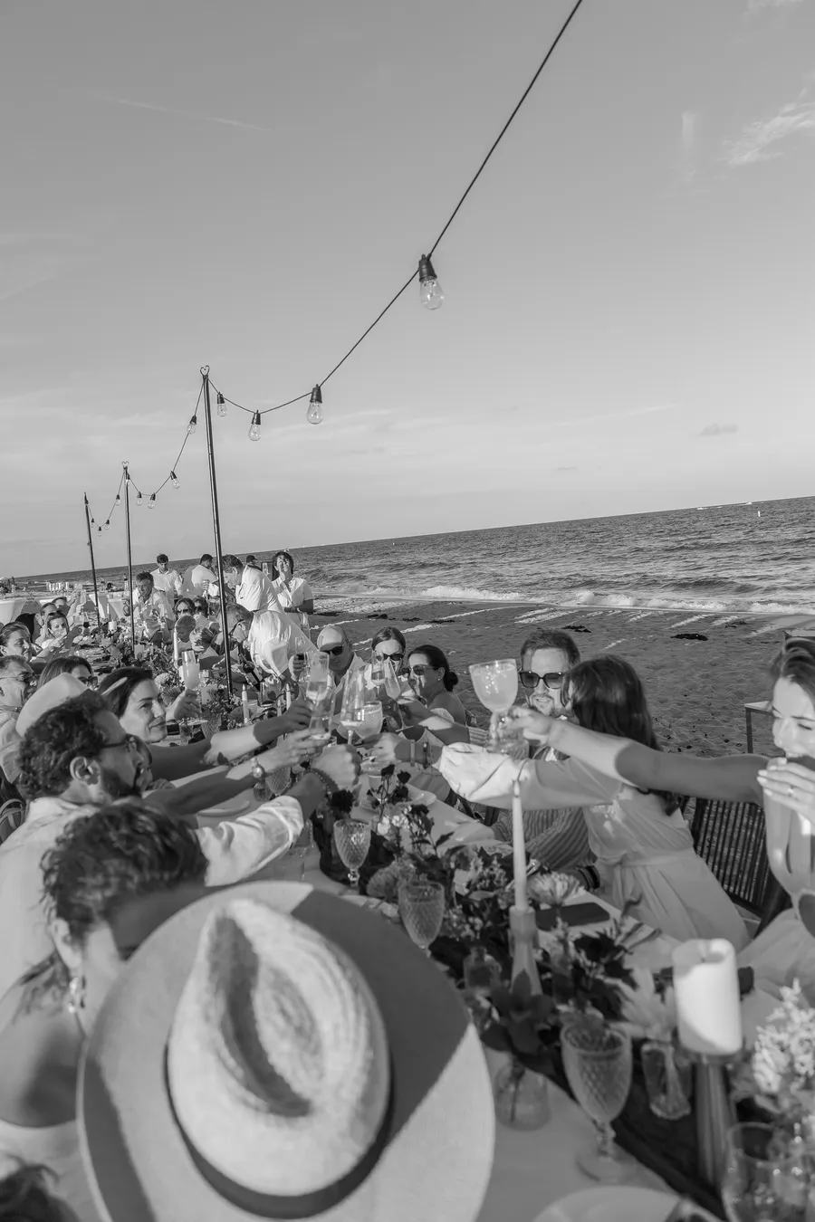 Black-and-white reception table beside the sea — Roman and Victoria wedding
