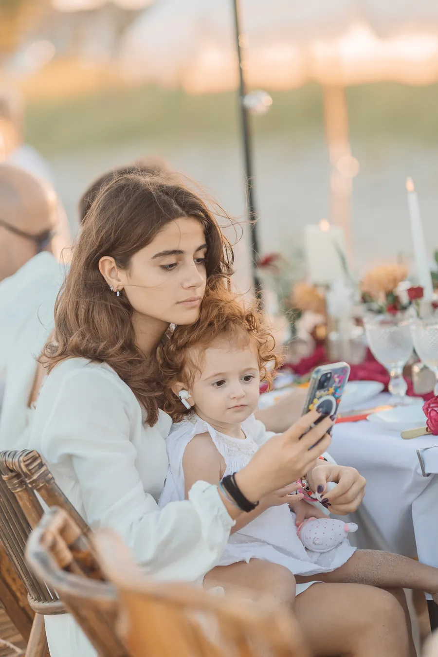 Guests seated at a long seaside reception table — Roman and Victoria wedding