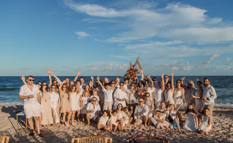 Large wedding party celebrating together beside the ocean
