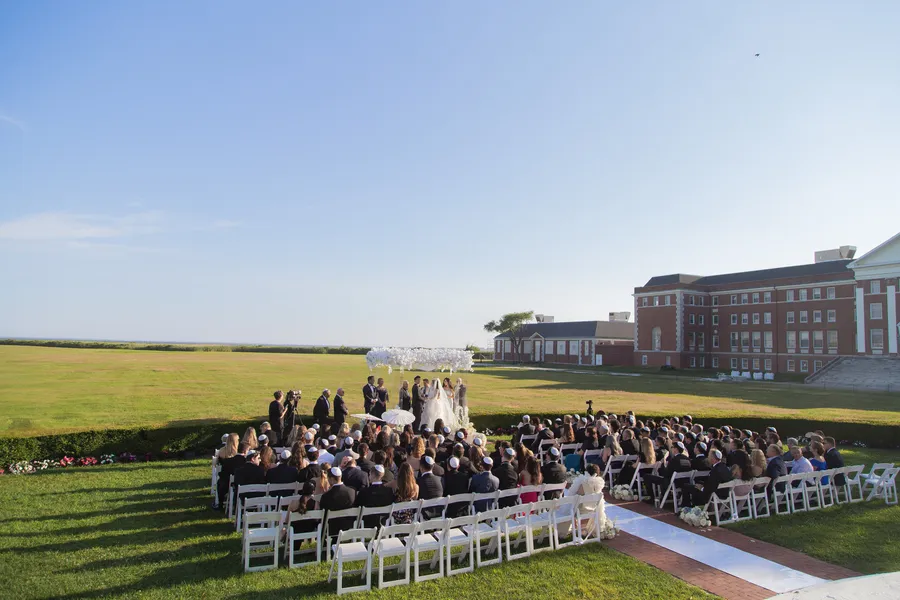 Guests seated for a large outdoor estate wedding ceremony