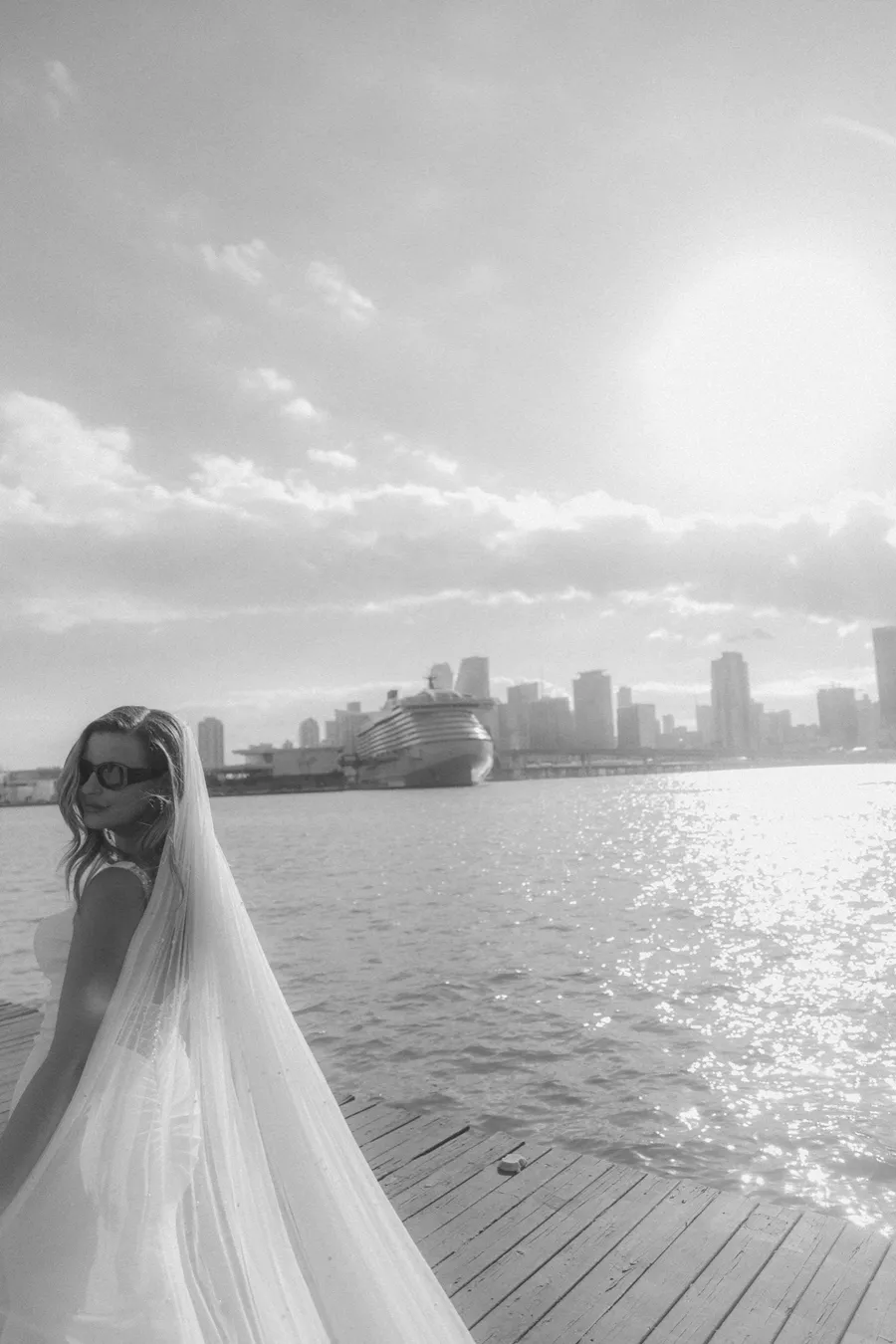 Black-and-white portrait of a bride looking across the water