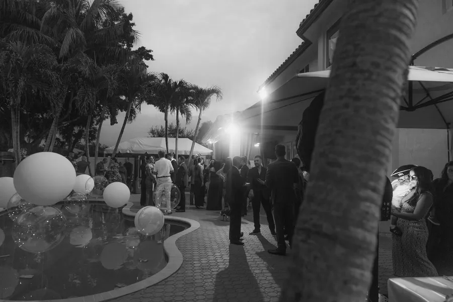 Black-and-white nighttime reception beside the pool — Chris and Laura wedding