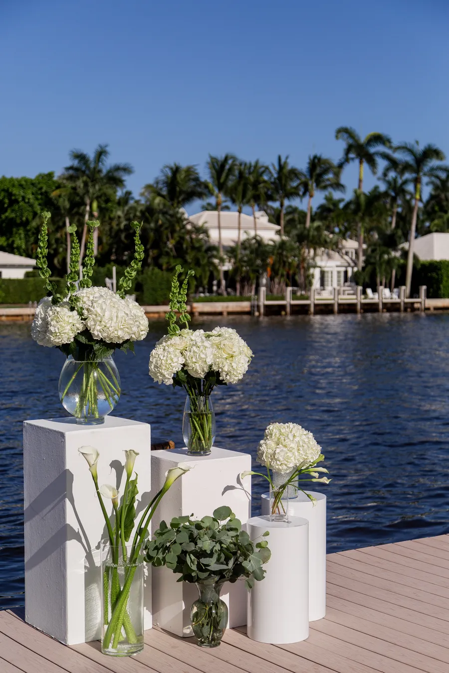 Waterfront ceremony setup with white floral arrangements — Alexander and Olga wedding