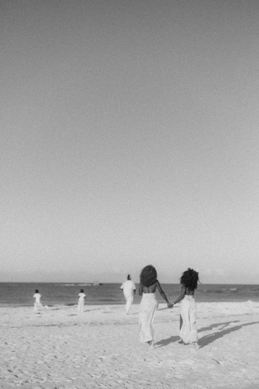 Black-and-white family moment beside the Gulf shoreline
