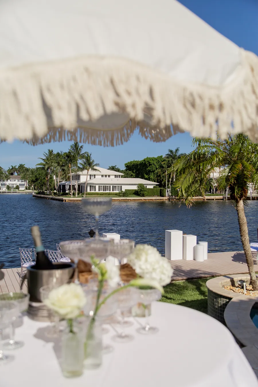 Waterfront reception table with white flowers and tropical views