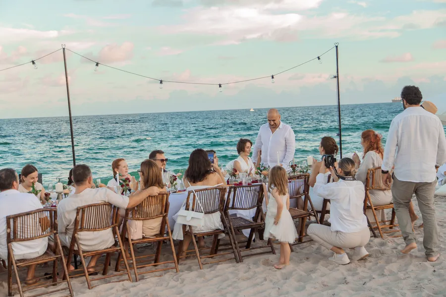 Guests seated at a long seaside reception table — Roman and Victoria wedding