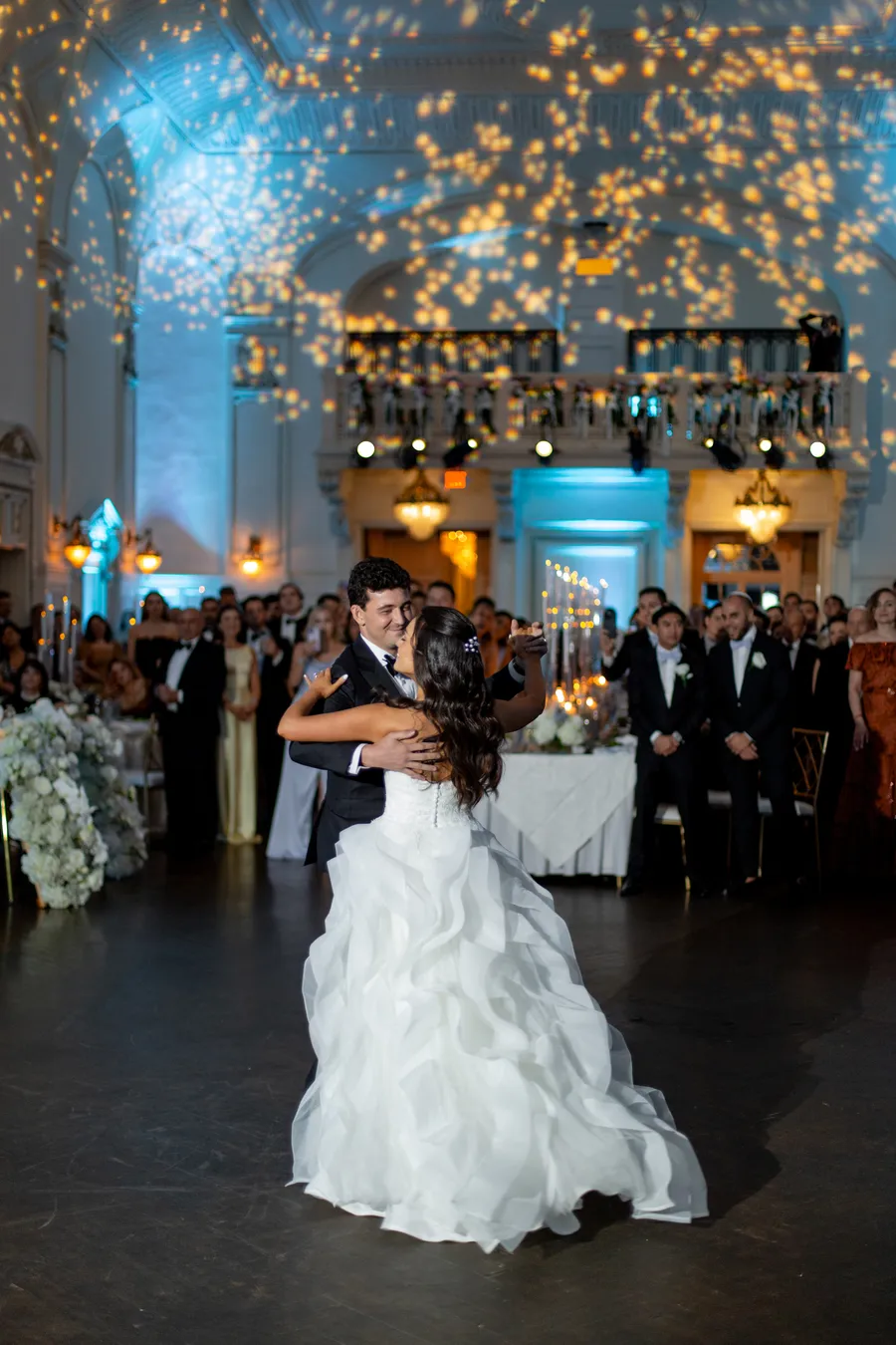 Bride dancing beneath warm reception lights