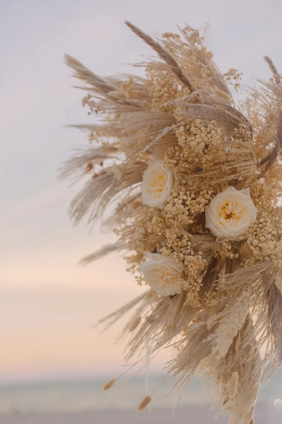 Dried floral wedding arrangement at sunset by the sea