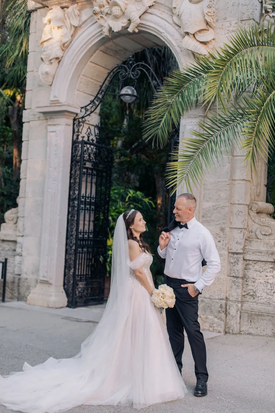 Bride and groom beside ornate stone architecture — Steven and Iryna wedding