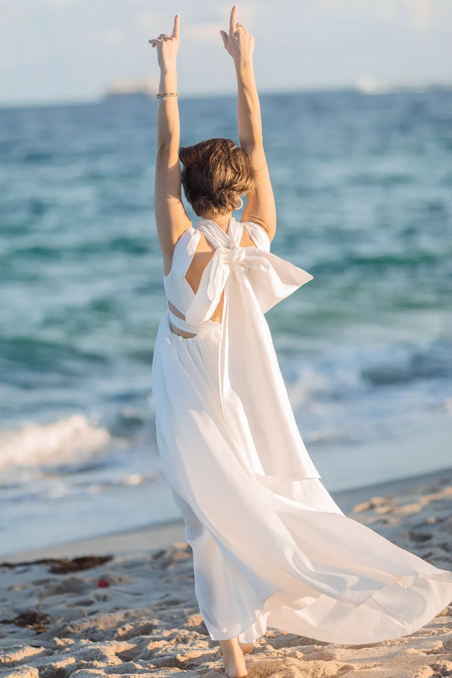 Bride celebrating beside the ocean — Roman and Victoria wedding