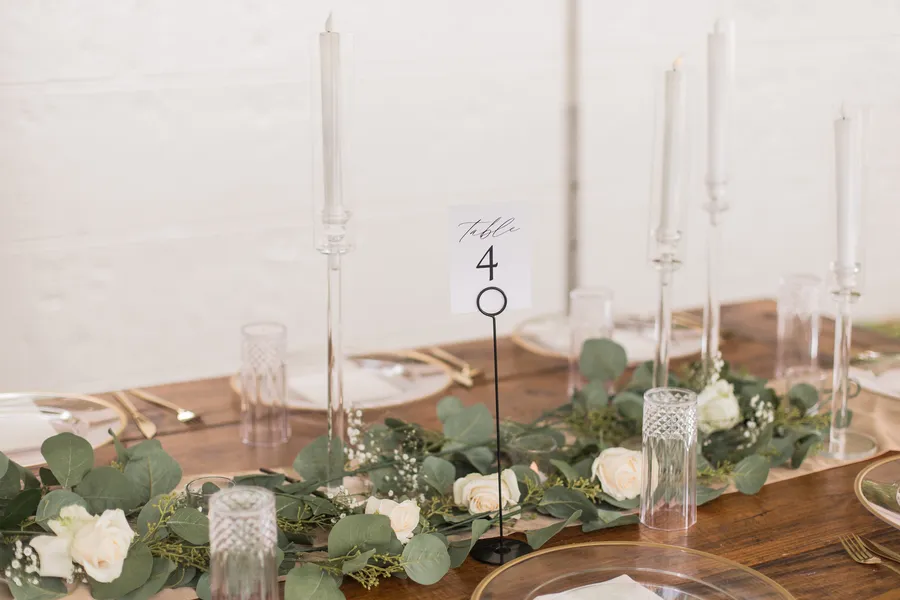 White floral ceremony arrangement beside wooden chairs — Chris and Laura wedding